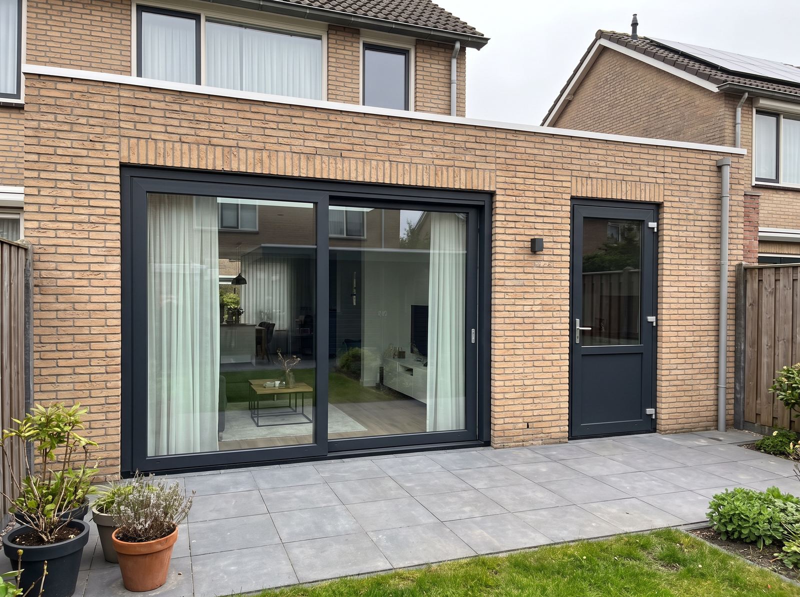 Achtergevel met een nieuwe schuifpui en achterdeur naast elkaar, door Trizo in Goirle