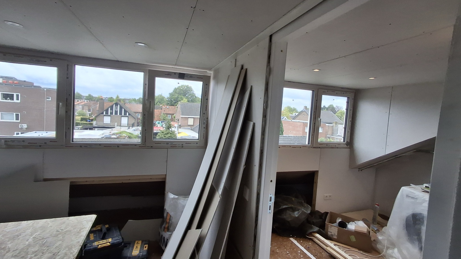 Twee nieuwe dakkapelkozijnen in een zolderruimte die nog in aanbouw is