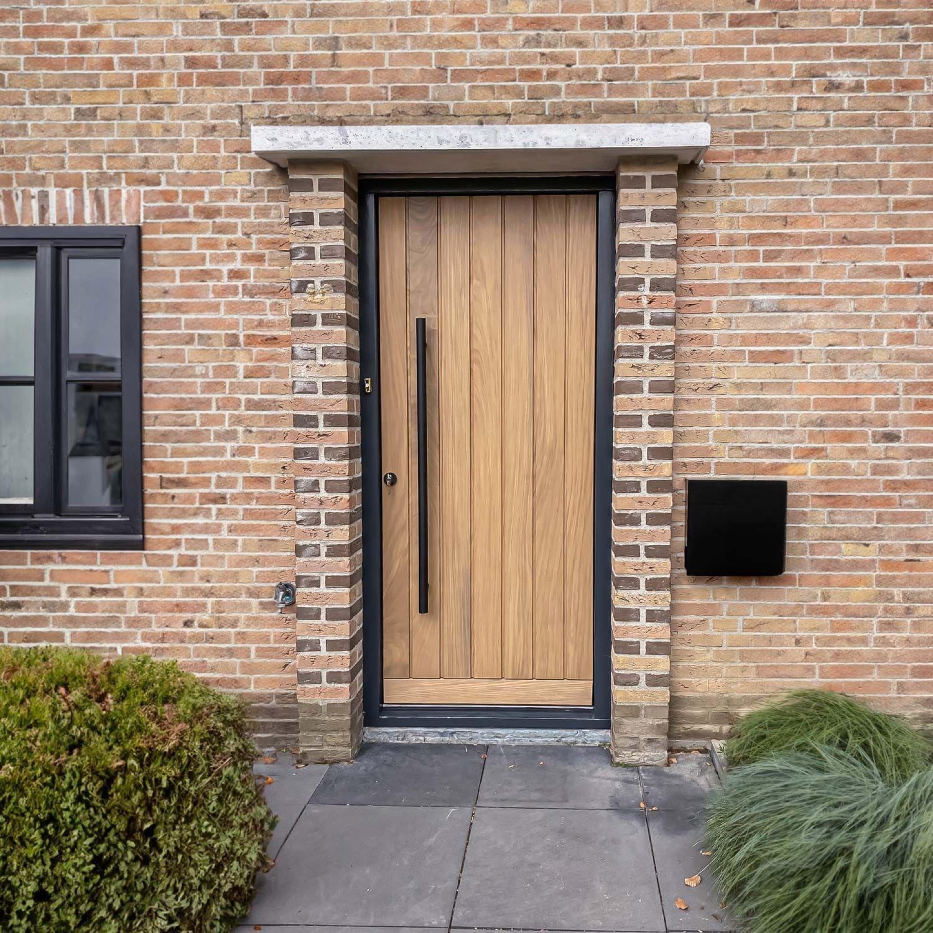 Afgewerkte houten voordeur in een zwart kozijn, geplaatst door Trizo in regio Tilburg
