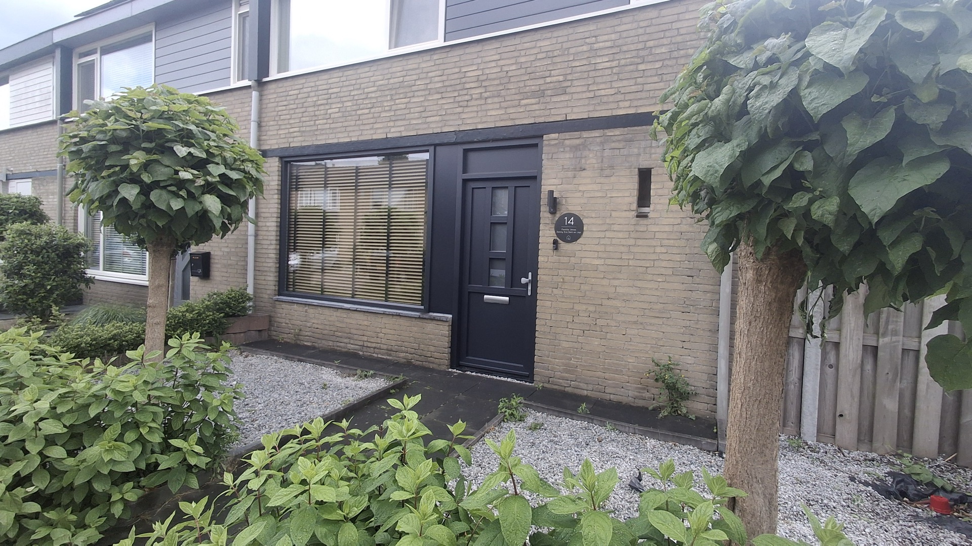 Twee kunststof kozijnen in een woonkamer, gezien van binnenuit met de rolgordijnen neer