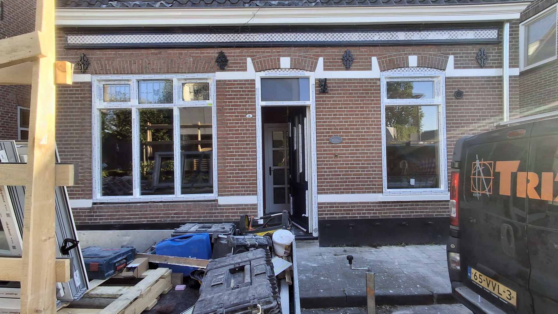 Nieuwe kunststof kozijnen en voordeur in een renovatiewoning, met de bedrijfsbus van Trizo voor de deur