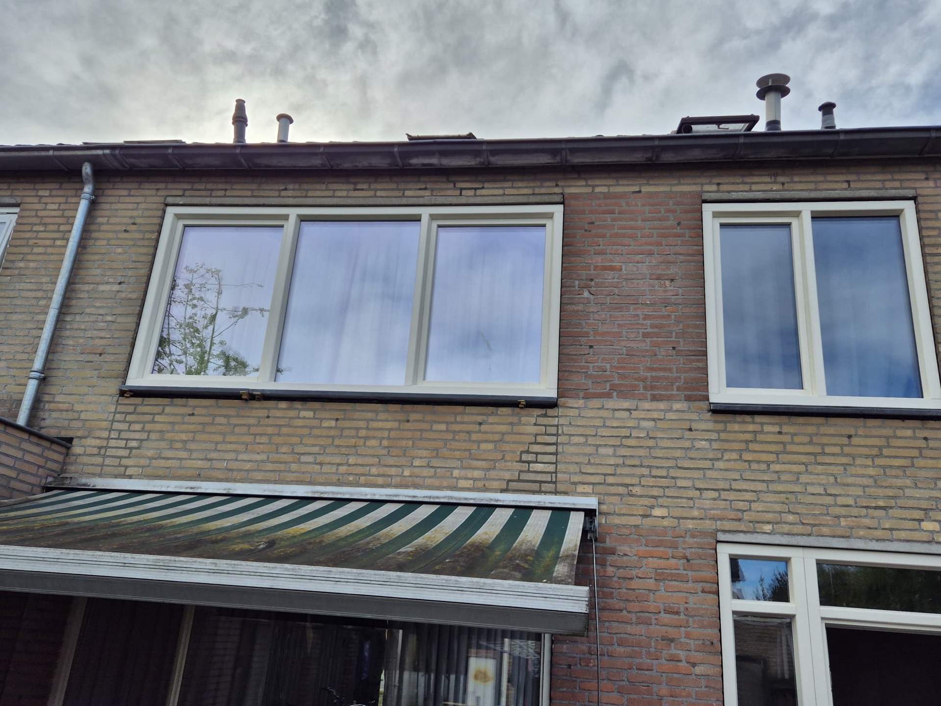 Twee grote witte kunststof kozijnen in de gevel van een woning