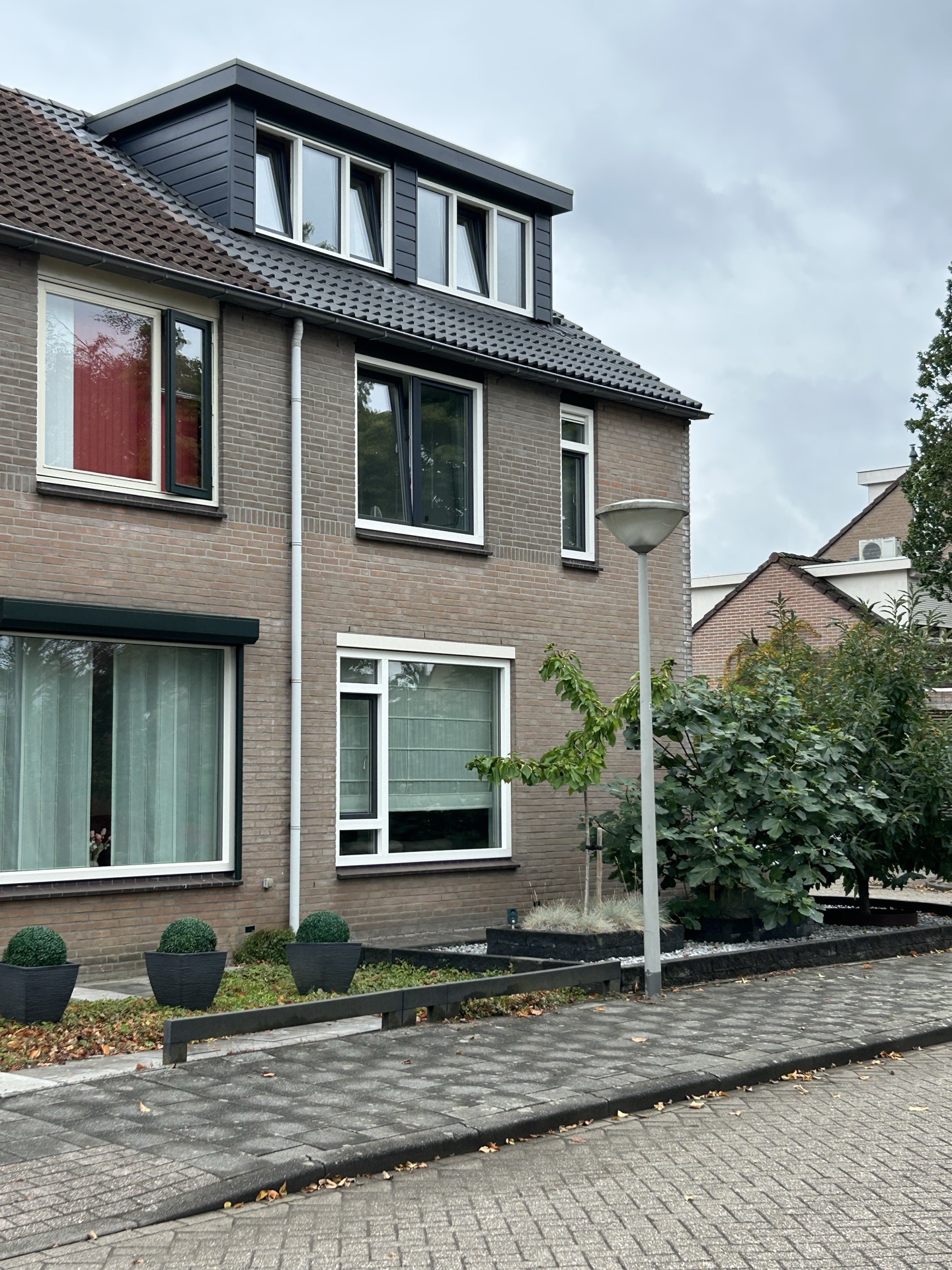 Nieuw antraciet pannendak, direct naast het oude pannendak van de buren, vervangen door Trizo in regio Tilburg